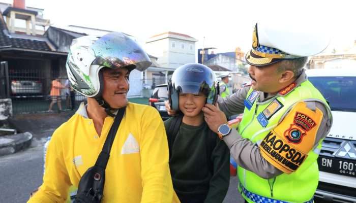 Bagikan Helm Gratis, Polantas Ingatkan Pengendara Tentang Kesadaran Tertib Berlalu Lintas